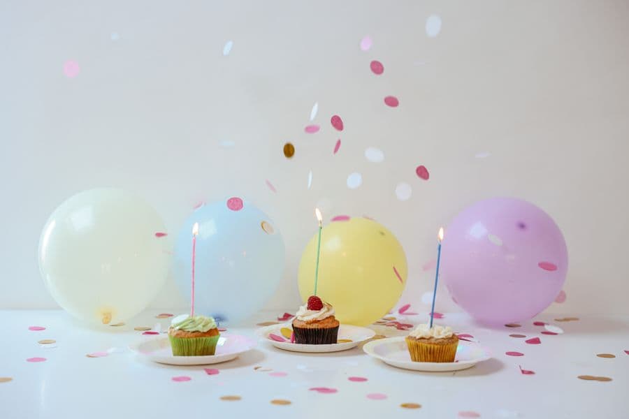 Illustration: cupcakes, balloons and confetti on a party table