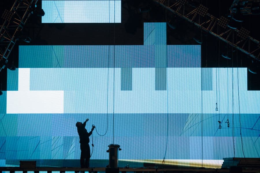 Illustration: a technician installing a large digital stage screen