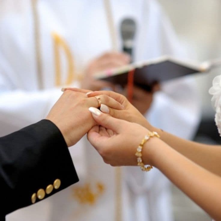 A couple exchanging rings during a Christian wedding ceremony.