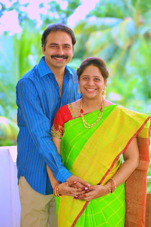 A couple photographed together outdoors in a posed portrait.