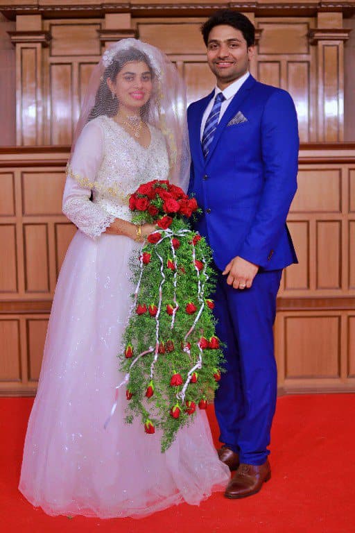 A bride and groom standing together indoors after a church wedding.