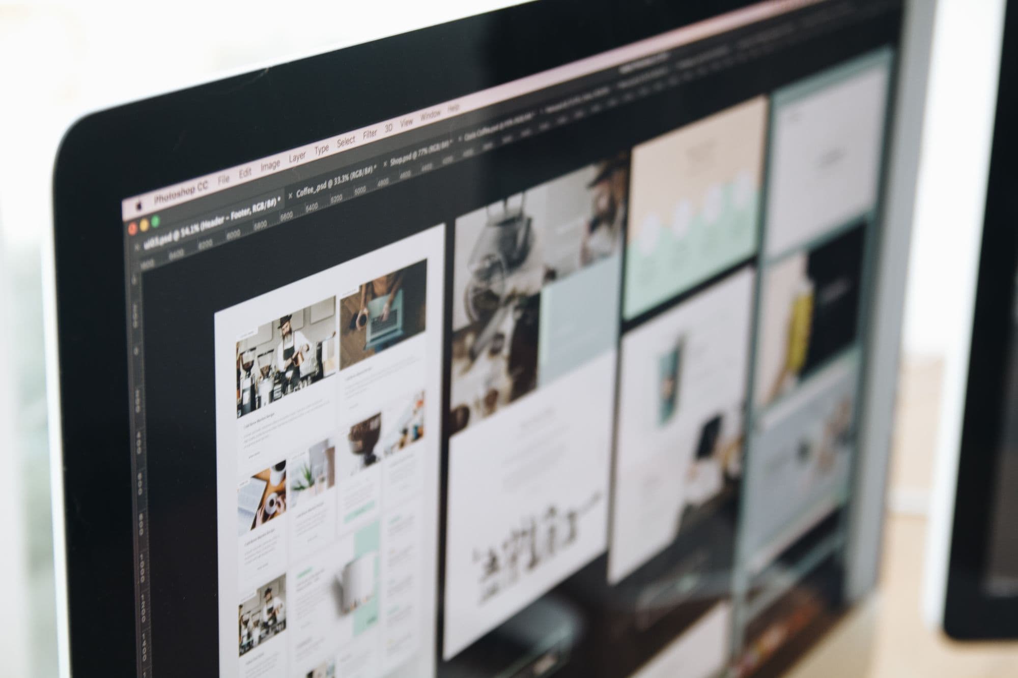 A close view of a monitor showing a website design in an editor.